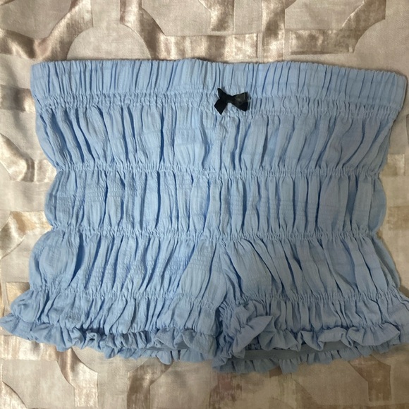 Light blue stretchy shorts with a small cute black bow. - Picture 1 of 5
